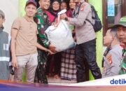 Die Polizei verteilt Grundnahrungsmittel an von Überschwemmungen betroffene Bewohner in Pegangsaan Dua Nord-Jakarta